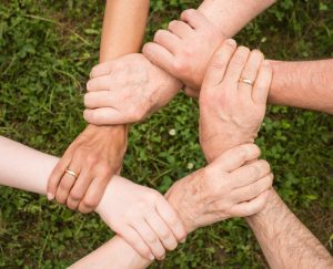 Group of people holding arms